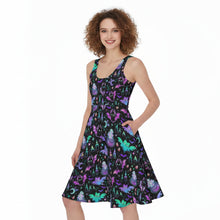 Load image into Gallery viewer, A woman modeling a sleeveless A-line dress with a black background and a colorful print of cartoon monsters, including a purple cat, green frog, and blue dragon, against a plain white studio background.