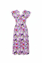 Load image into Gallery viewer, A woman models a short-sleeve midi dress with a purple and white cartoon dog pattern, featuring 'BOO! BOO! BOO!' text and balloons. She is wearing a straw hat and holding a small woven handbag against a plain white background.