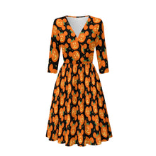 Load image into Gallery viewer, A three-quarter sleeve V-neck dress with a black background and an all-over orange jack-o'-lantern pattern, shown on a neutral gray gradient background.
