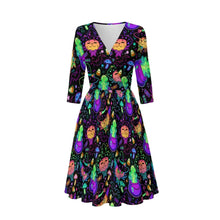 Load image into Gallery viewer, A three-quarter sleeve V-neck dress with a flared skirt, featuring a vibrant neon-style print of cartoon witches wearing purple hats and holding cauldrons on a black background.