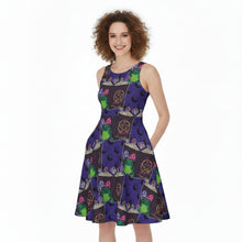 Load image into Gallery viewer, A woman with curly brown hair wearing a sleeveless fit-and-flare dress with a colorful witch-themed print, standing against a plain white background.
