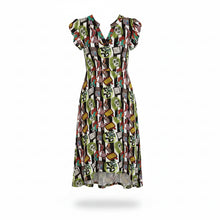 Load image into Gallery viewer, A woman wearing a short-sleeve V-neck dress with a busy multicolor print featuring skulls, books, and small illustrations on a black background. She is holding a woven straw handbag against a plain white background.
