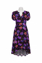 Load image into Gallery viewer, A short-sleeve midi dress on a mannequin, featuring a black base with a vibrant purple, pink, and orange pumpkin and floral pattern.
