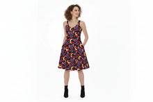 Load image into Gallery viewer, A woman modeling a sleeveless A-line dress with a colorful retro crescent moon pattern on a dark background, paired with black ankle boots, against a plain white studio background.
