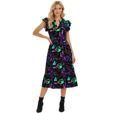 Load image into Gallery viewer, A woman modeling a midi-length black dress with a vibrant neon multicolor print of skulls, pills, and other occult motifs, paired with black ankle boots against a plain white background.

